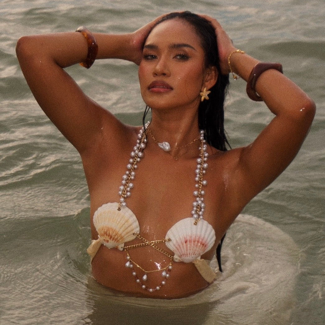Woman in water wearing a shell and pearl necklace